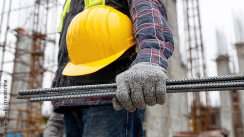Construction worker holding rebar on site