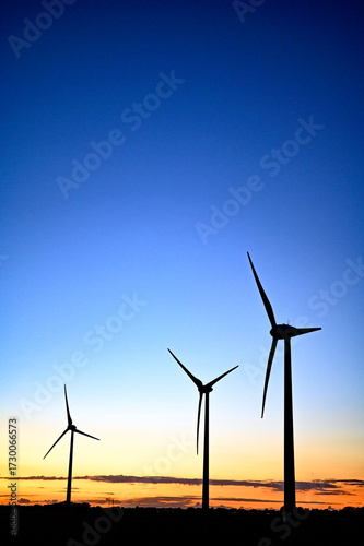 Beautiful colourful sunset silhouettes of wind turbines, windmill, copy space.