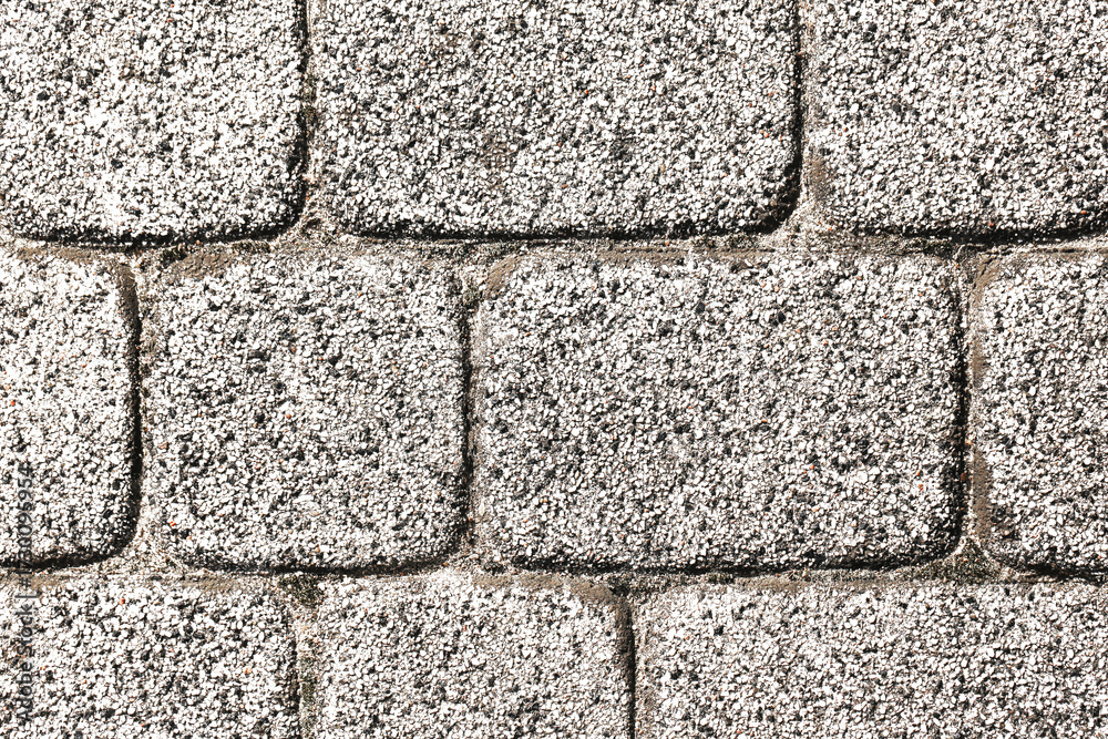 Fototapeta premium Stone pavement texture. Gray cobblestone surface background. Square stone pattern closeup. Urban architecture flooring. Natural stone block wall. Exterior outdoor construction material.