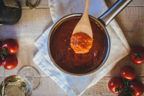spoon over pot filled with tomato sauce