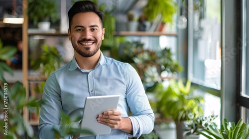 Man holding a tablet in a modern office environment.
