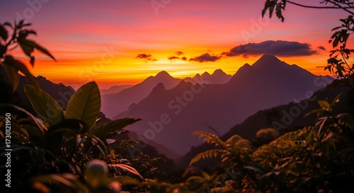 Breathtaking mountain range silhouette glows under vibrant sunset sky with lush foliage creating a serene and inspiring travel destination landscape