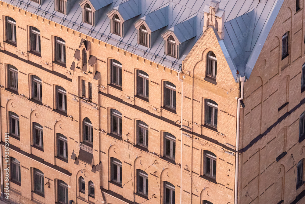 Fototapeta premium Facade of a multi-story residential building constructed in the 1920s–1930s, beautifully restored. Classic architectural details preserved, giving the building a charming and elegant appearance.