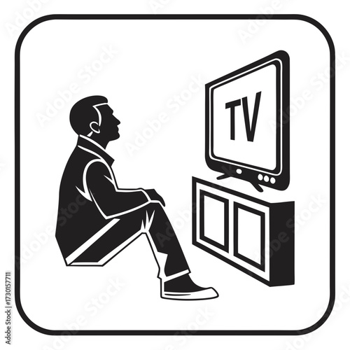 A man sitting on the floor in silhouette watching television on a stand with the word tv displayed on the screen