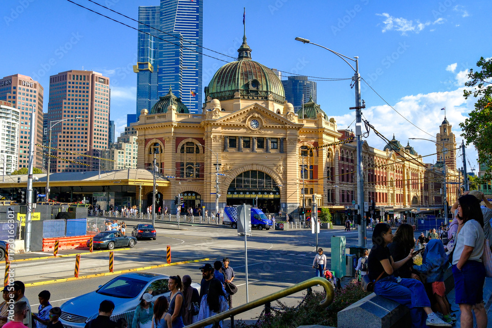 Obraz premium Flinders Street Station in Melbourne, Australia, with busy street life and modern skyscrapers in the background, showcasing the city’s historic and urban contrast.