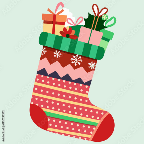 Colorful christmas stocking overflowing with festive gifts and holiday decorations on a pale green background
