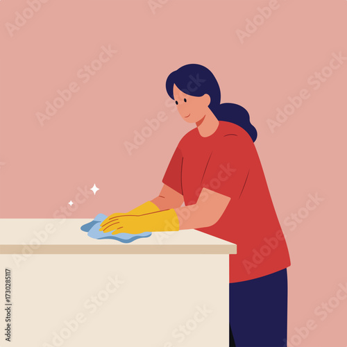 Woman wiping table wearing gloves, implied cleanliness, on pink background