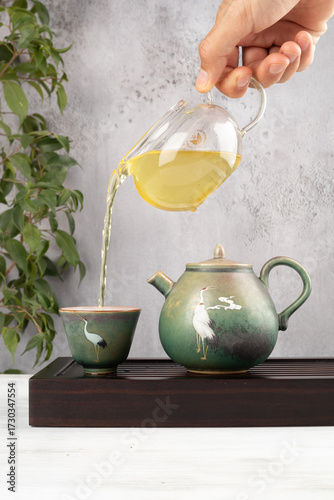 Teapot pouring green tea, tea ceremony. 