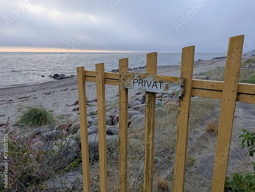 View of a private beach that was fenced off with a private sign early in the morning