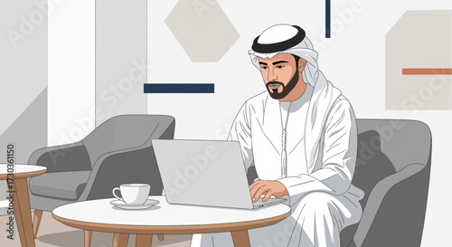 An Arab man dressed in traditional clothing sits at a table using a laptop in a modern, minimalist setting.