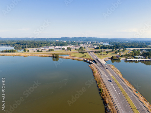 Wallpaper Mural Aerial View Of Bridge Over Coosa River, Interstate 759 and Highway 411, Lush Forest, And Distant Hillscape Under Clear Sky. The tranquil water reflects the blue sky, creating a scenic landscape. Torontodigital.ca