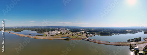 Wallpaper Mural Aerial View Of Bridge Over Coosa River, Interstate 759 and Highway 411, Lush Forest, And Distant Hillscape Under Clear Sky. The tranquil water reflects the blue sky, creating a scenic landscape. Torontodigital.ca