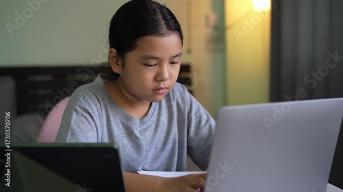 asian child learning on computer laptop typing by study online class or kid girl student fun studying by notebook or young people happy learn from home school by tablet technology education in room