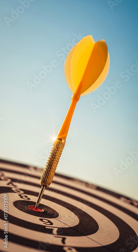 Close-up of yellow dart in bullseye, against a clear blue sky, representing success, achievement, and target accomplishment in business