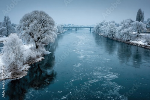 Winter river landscape with frosted trees and bridge