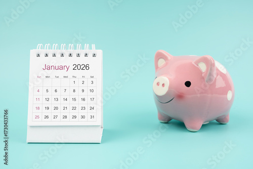 Wallpaper Mural January 2026 Desk calendar and pink piggy bank on blue background. Torontodigital.ca