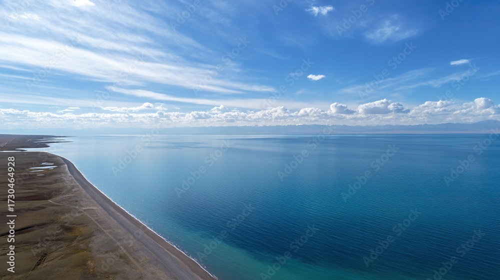 Obraz premium From a panoramic perspective, overlooking the vast lake, the deep blue water contrasts sharply with the expansive desert landscape, showcasing the natural beauty of the area.