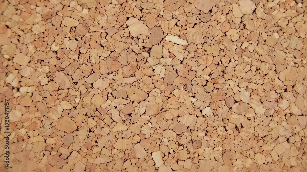 Close up of a cork board texture with small granules and irregular shapes.
