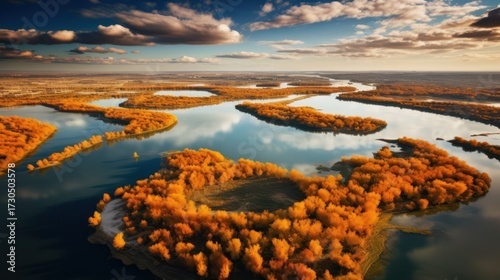 aerial view, autumn landscape, colorful forest, lake, calm water, dramatic sky, clouds, sunlight, reflection, scenic, nature, fall foliage, tranquil, serene, atmospheric, cinematic
