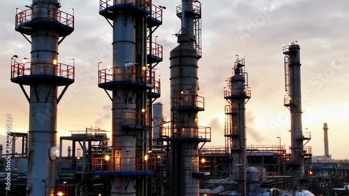 Industrial Complex Towers Silhouettes Against Sunset Sky Evening.
