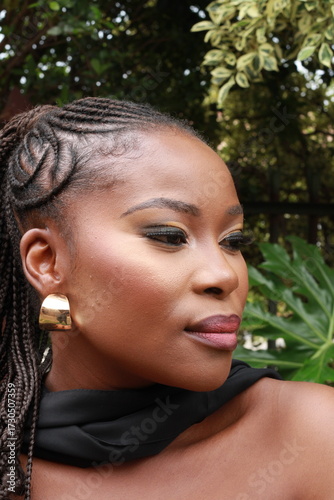 Beautiful African Black Woman with gold earrings  and makeup with braided hair