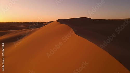 Golden Sand Dunes Shimmering Under a Warm Sunset Sky in a Vast Desert Landscape