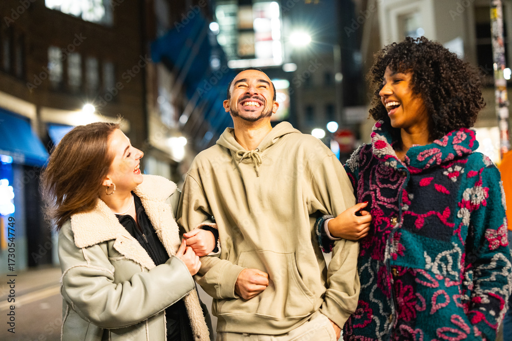 Fototapeta premium Diverse friends laughing and enjoying night out in city