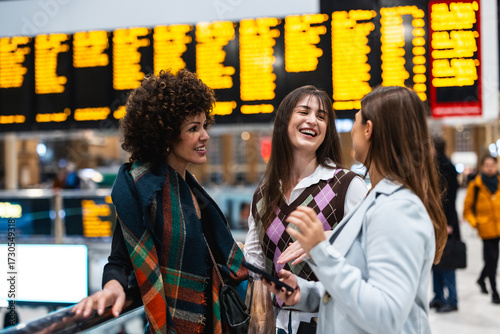 Women friends laughing together at train station