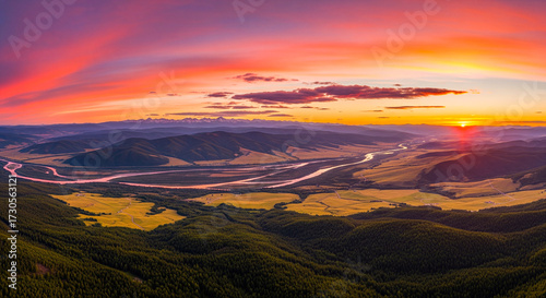 Sunset Panorama over Valley: Captivating panorama captures the stunning hues of sunset casting an warm glow over the valley's rolling hills, fields, and a meandering river.