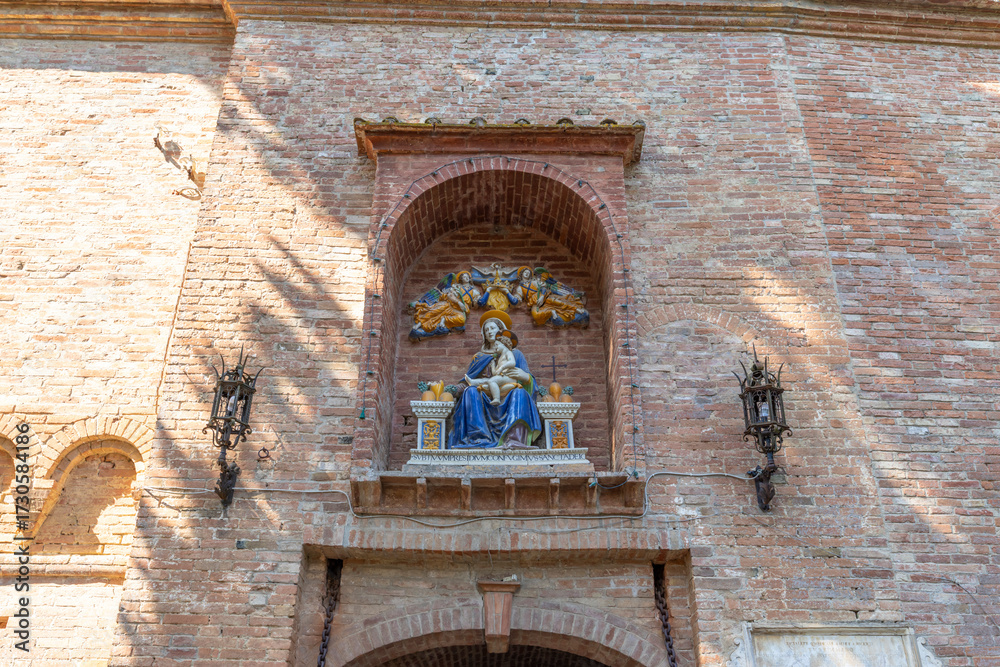 Obraz premium Madonna and Child statue on old brick wall