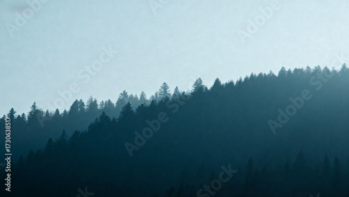 Silhouetted forested hillside under a hazy sky