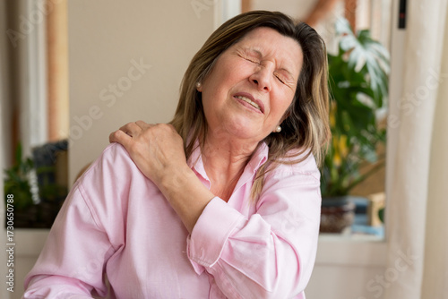 Bilde på lerret Senior woman experiencing intense shoulder pain and discomfort, suffering from h