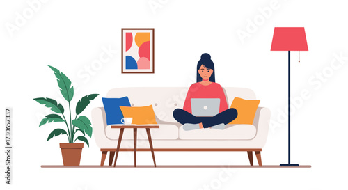 A young woman working on a laptop at home on a couch.
