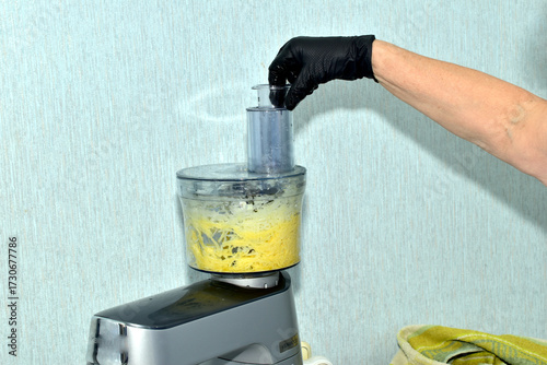 The picture shows a food processor's electric grater with chopped vegetables inside.