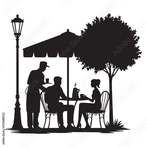 Silhouette of a couple enjoying a romantic outdoor cafe meal under a large umbrella with a waiter serving them next to a lamppost and tree