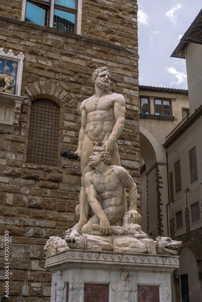 Obraz premium Sculpture depicting muscular figures in front of stone building. Renaissance artistry and historical context are vividly portrayed.
