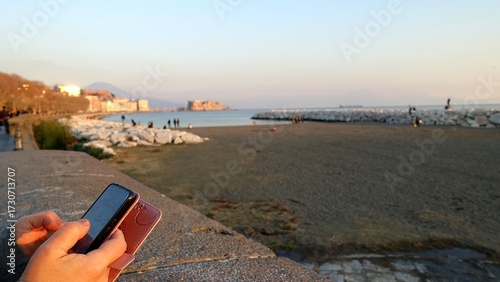Relaxing with my cell phone in hand on the Naples seafront as the sunset light.