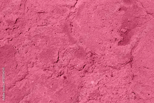 A vivid pink wall texture featuring rough, cracked surface and weathered deta...