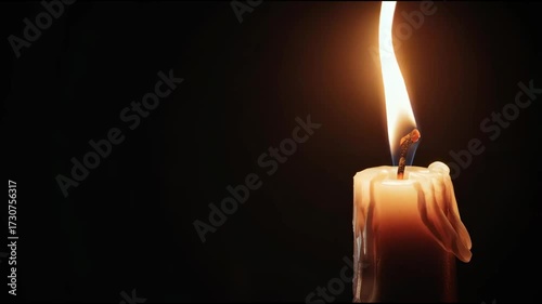 Candle flame flickers in dark room creating warm atmosphere and calming effects