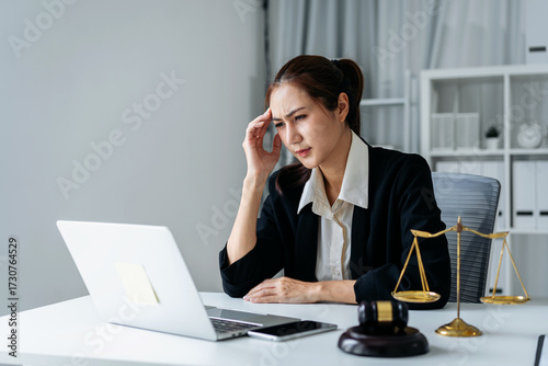 Professional woman workplace stress headache office desk legal challenges corporate governance ESG matters for business solutions