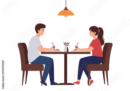 Two people sit at a table with food and drinks under a lamp