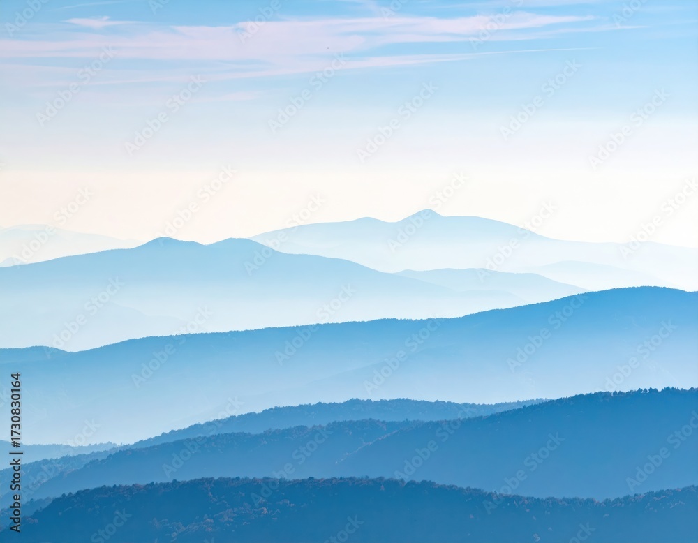 Obraz premium Blue layered mountain range landscape in morning fog.