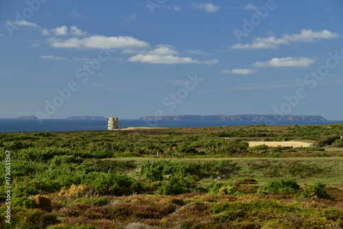 Les Landes common, Jersey, U.K. WW2 radio tower from the German occupation in a green coastal landscape with other Channel islands on the horizon.