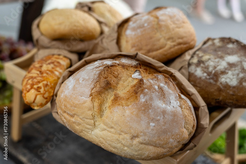 Freshly baked artisanal bread loaves displayed in a rustic basket, showcasing a variety of textures and colors, inviting customers to enjoy delicious baked goods