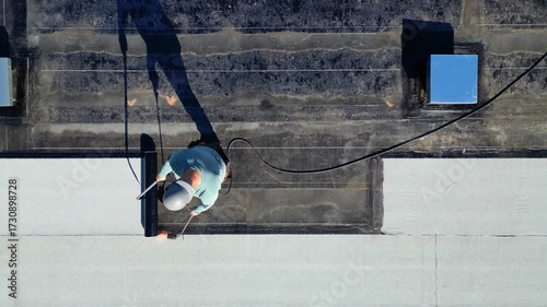 Roofer applying torch to bitumen membrane on torch down roof