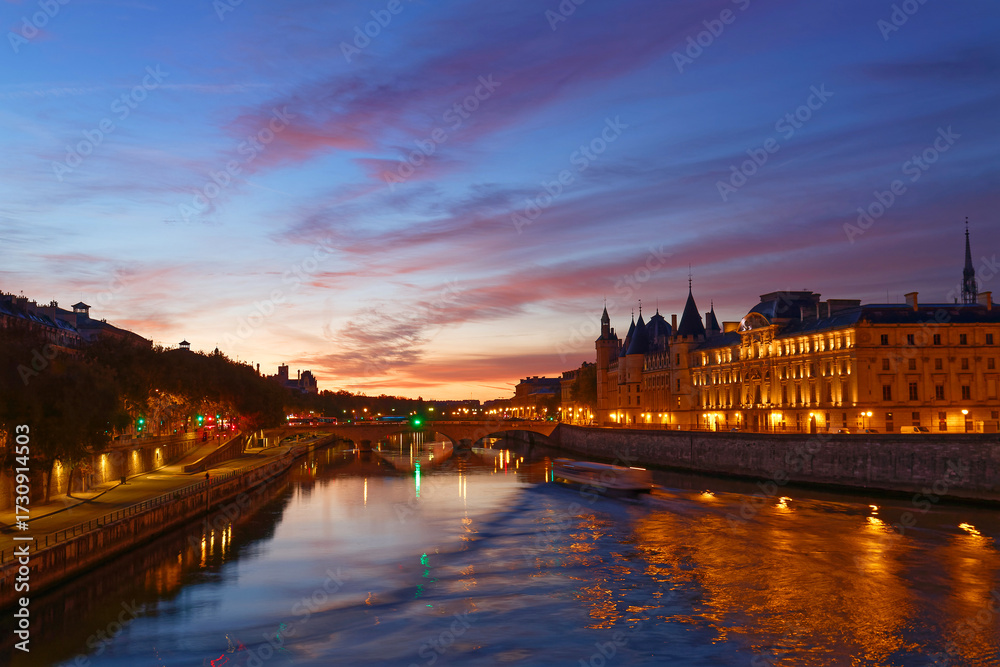 Fototapeta premium Conciergerie building located along of the Seine river and the center of Paris under a early sunrise lights. It was successively King's palace the prison and justice hall in French history.