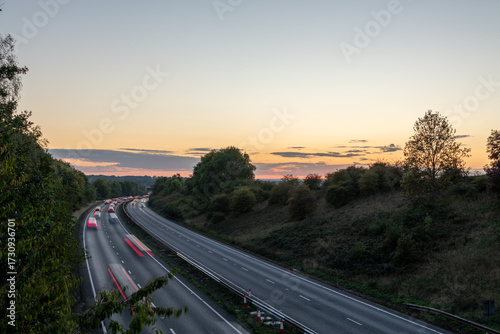 Long exposure image of traffic with streaking lights on a highway at sunset.