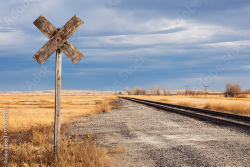 Rural railway crossing sign with dramatic cloudy sky