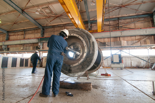 Certified mechanical technician performing maintenance work on an industrial water pump in a mechanical workshop at a geothermal power plant in Mexico.