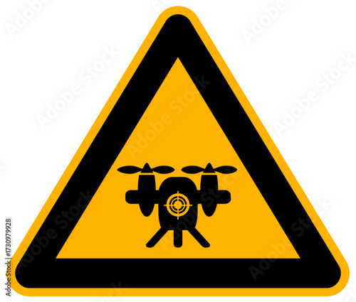 Warning sign: Black silhouette of a military or combat drone (UAV) with a crosshair in the center, set inside a classic yellow triangular caution sign.